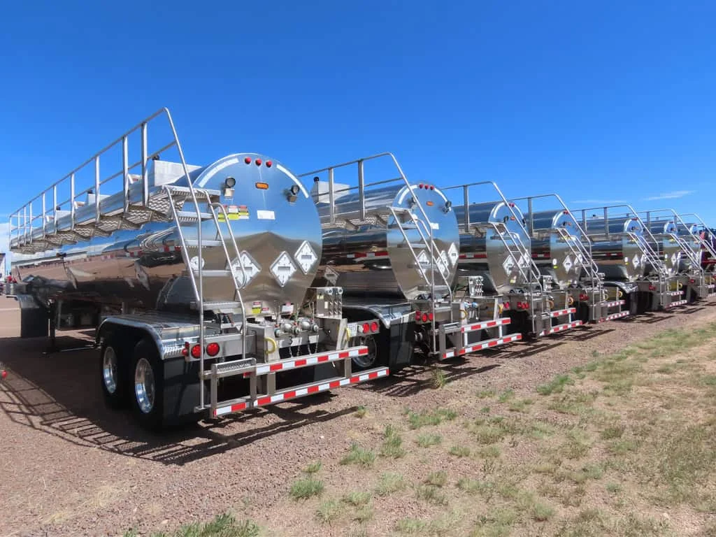 Parked oil drilling rigs on a gravel lot